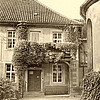Eingangsbereich des Klosters Marienwerder Mitte des 20. Jahrhunderts mit Flügeltür und einem Balkon, der mit Pflanzen bewachsen ist.